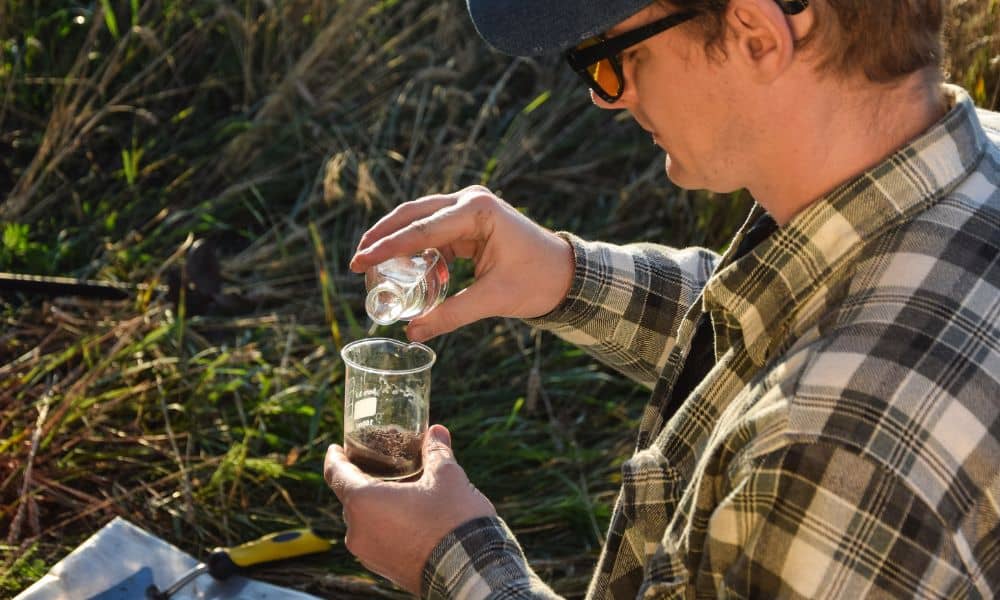 Surveyor testing soil with water sample for a perc test in San Diego land development