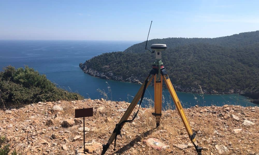 GPS survey equipment set up on a coastal hilltop for an elevation survey assessing flood risk