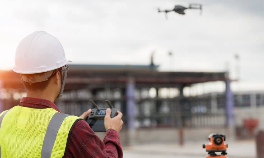 A surveyor performing a drone survey at an active construction site