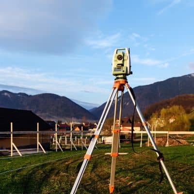 Surveying equipment measuring layout and elevation during a construction staking survey

