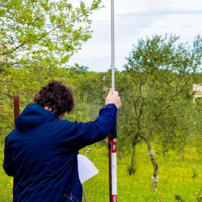 Field technician collecting measurements with GNSS equipment during a property survey