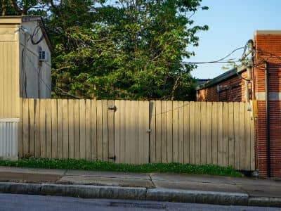 Wooden fence between two homes where the exact boundary survey line is not clearly visible, showing how property lines can be misleading